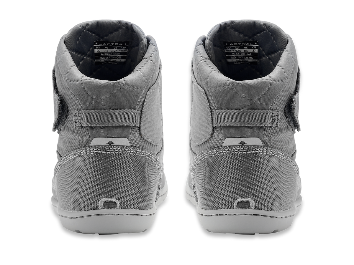 Back view of a pair of gray Astral Hiyak water shoes, featuring a high-top design, textured heel, and visible brand tags.