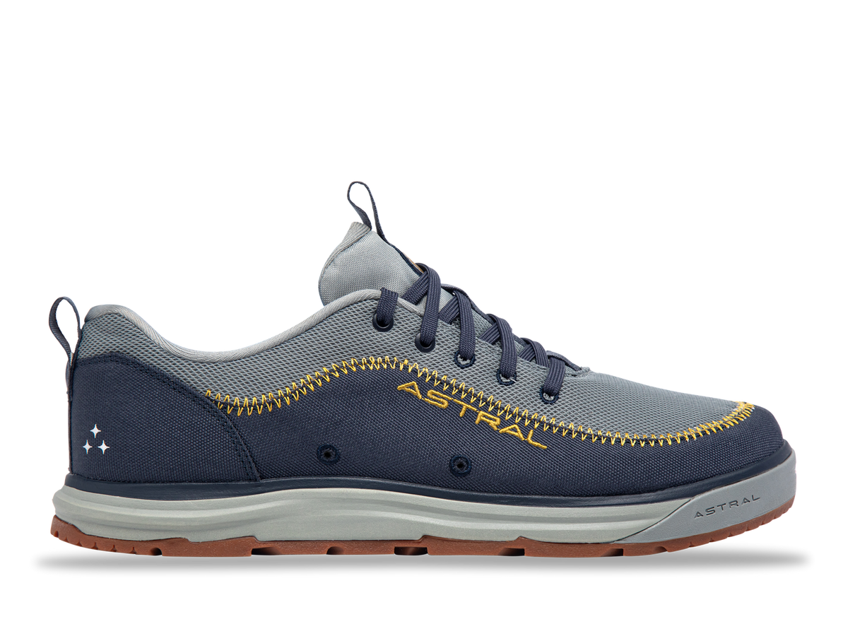 Astral Brewer shoe, side view, dark blue and grey with yellow stitching, breathable mesh, rugged sole for water and trail use.