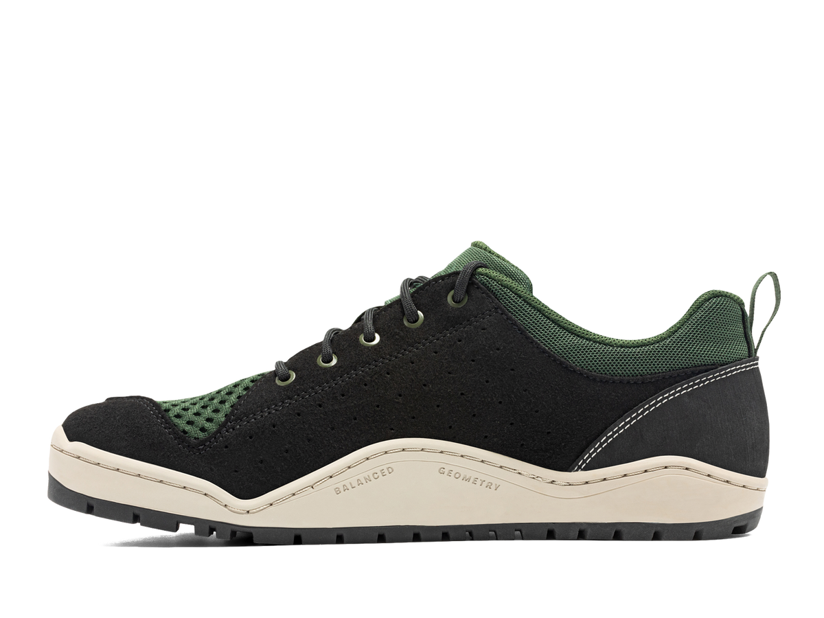 Techyak | Astral black and dark green hiking shoe with light beige sole and white stitching, side view.