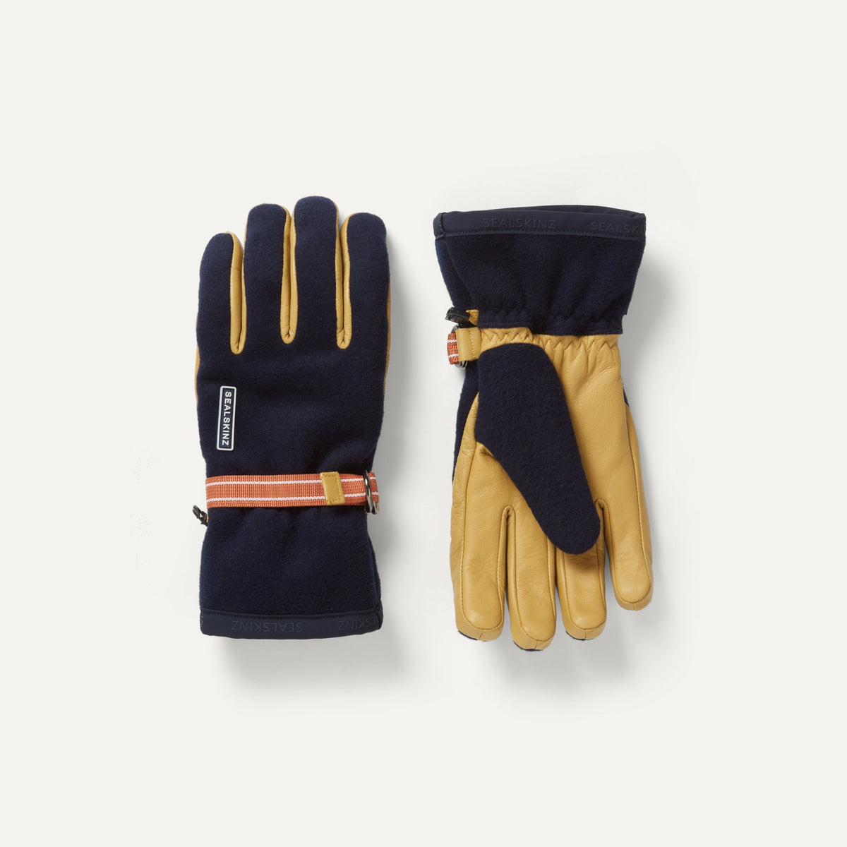 A pair of Sealskinz Toftwood Gloves, featuring navy blue textile and tan leather palms, with an orange striped wrist strap.