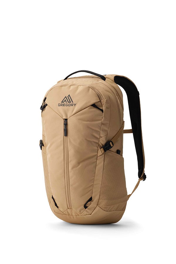 Gregory Signal 18 backpack in tan, showing the front with a main zipper, side mesh pocket, top handle, and shoulder straps.