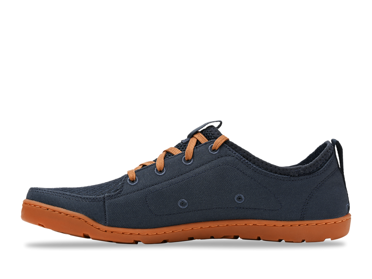Astral LoyakM navy blue casual shoe with orange laces and gum sole on a white background, side view.