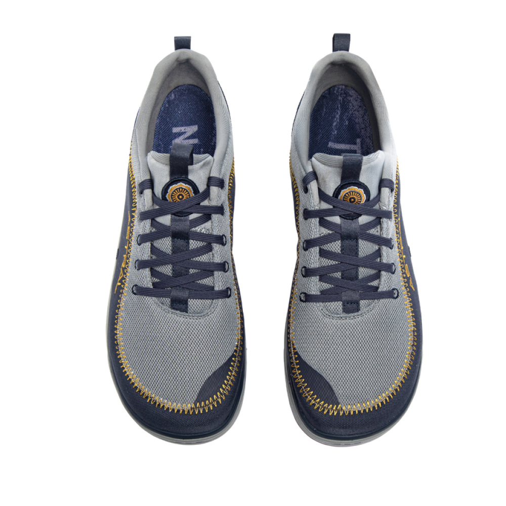 Top-down view of Brewer | Astral shoes in grey and navy blue with distinctive yellow stitching and laces.